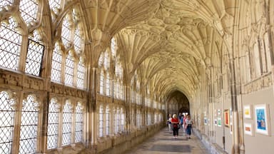 Interior de uma catedral com janelas em arco e um teto alto e ricamente decorado.