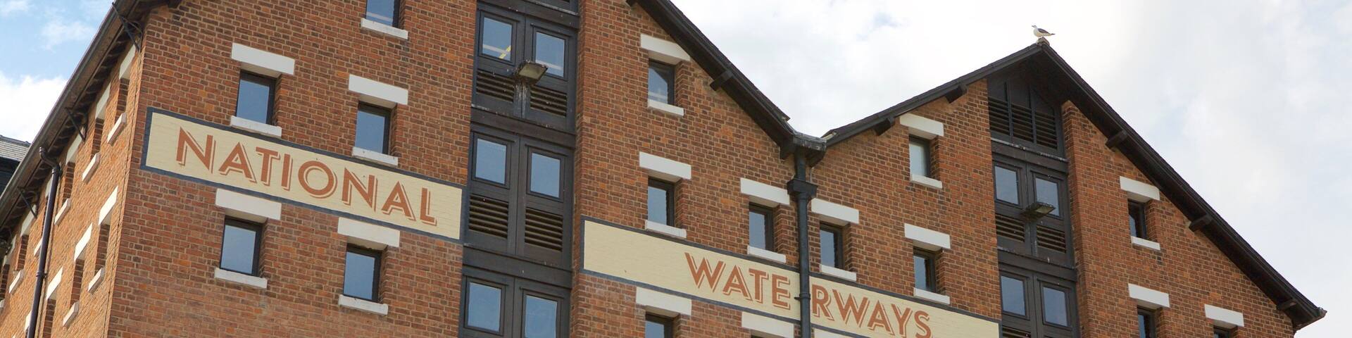 A multi-story building with signs for National Waterways, Llantony Warehouse, and Museum.