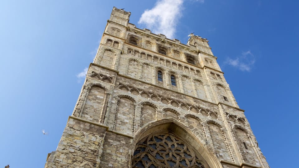 A tall stone tower with intricate carvings and a large arched window.
