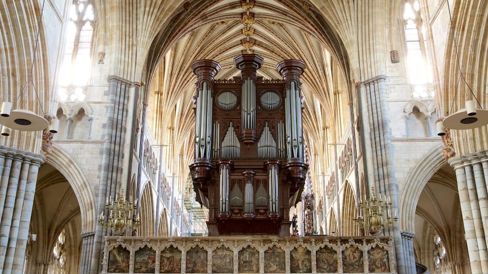 A cathedral interior with a large pipe organ, arched ceilings, and detailed wall paintings.