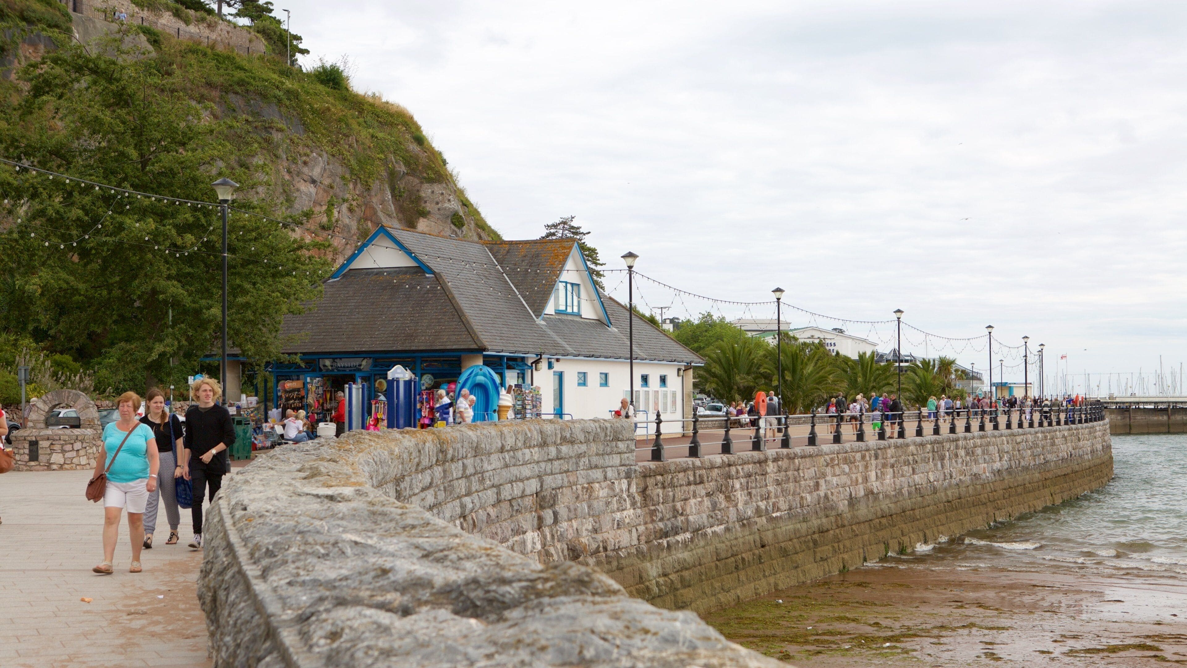 Abbey Sands showing cafe lifestyle and a beach as well as a small group of people