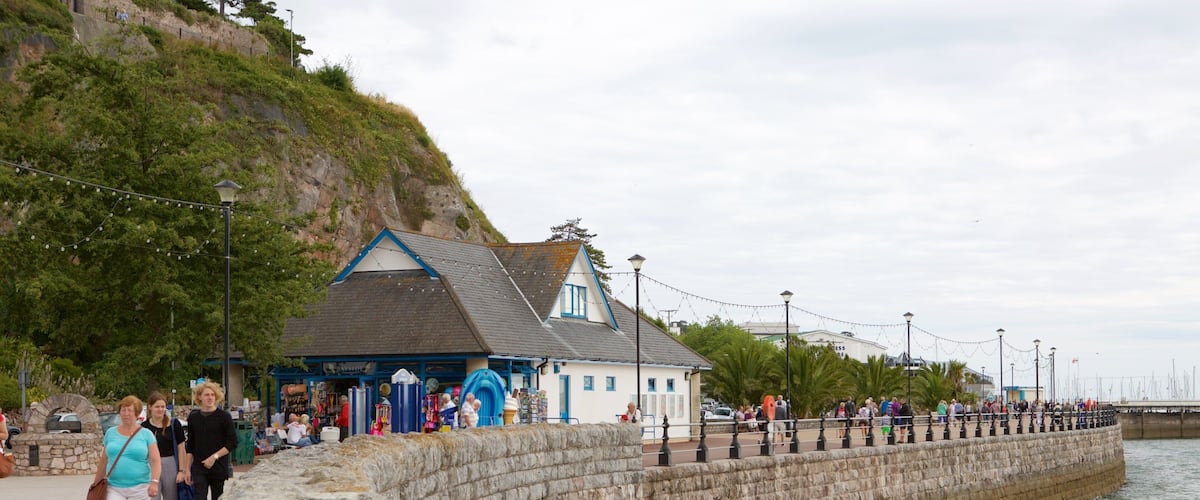 Abbey Sands featuring a sandy beach and café scenes as well as a small group of people