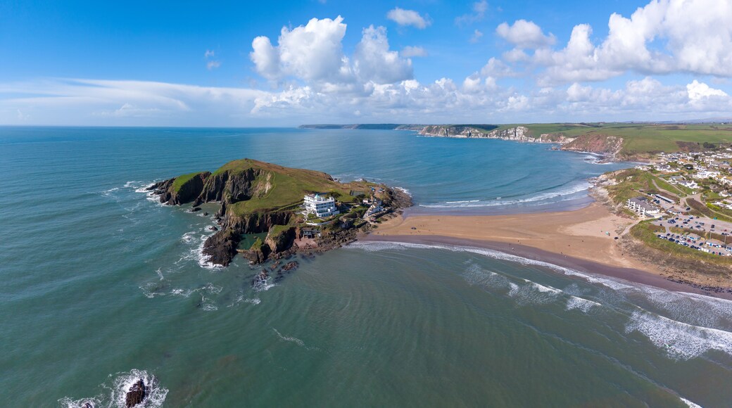 Aerial view of Burgh Island featuring the historic hotel, rocky cliffs, and sandy tidal causeway connecting to the mainland at Bigbury-on-Sea, England, United Kingdom.