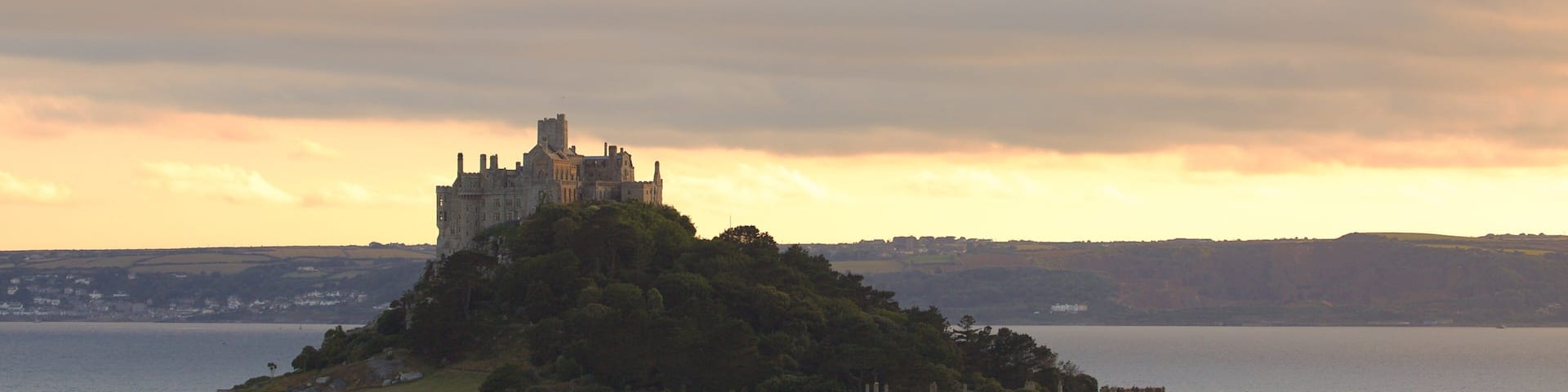 A castle on a hill overlooking a body of water.