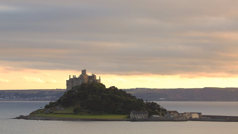 A castle on a hill overlooking a body of water.