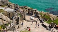 Minack Theatre featuring general coastal views and views as well as a large group of people