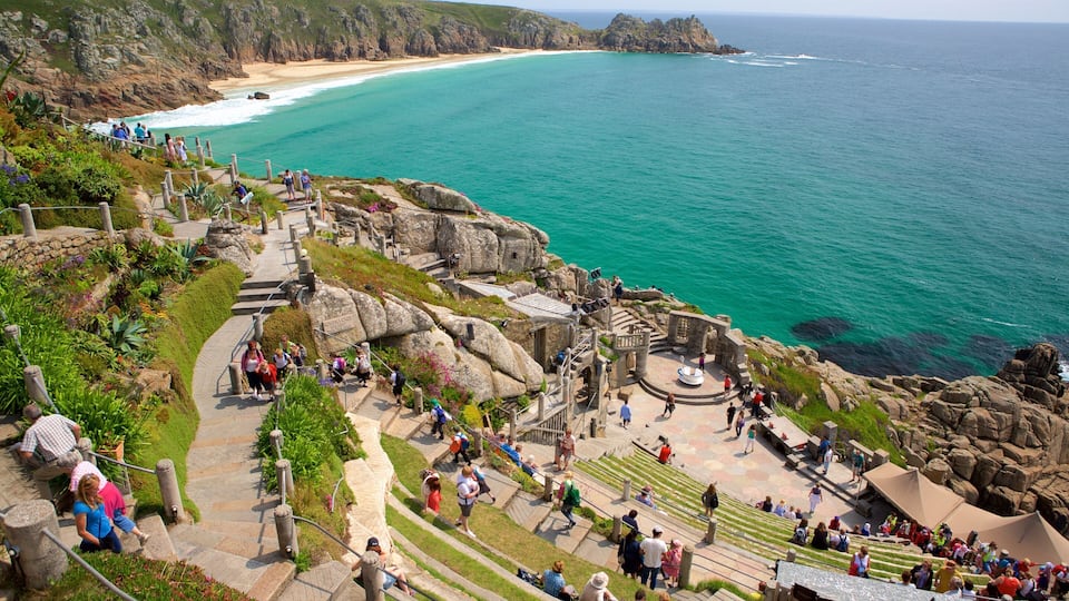 A coastal viewpoint with a stone staircase leading to a viewing platform overlooking turquoise waters and a sandy beach.