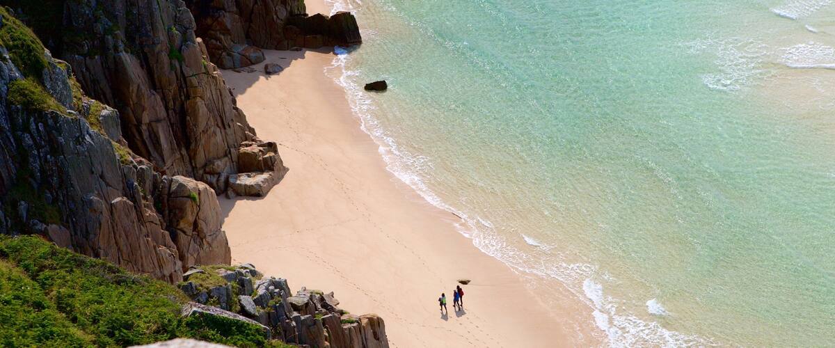 Porthcurno Beach que incluye litoral accidentado y una playa de arena