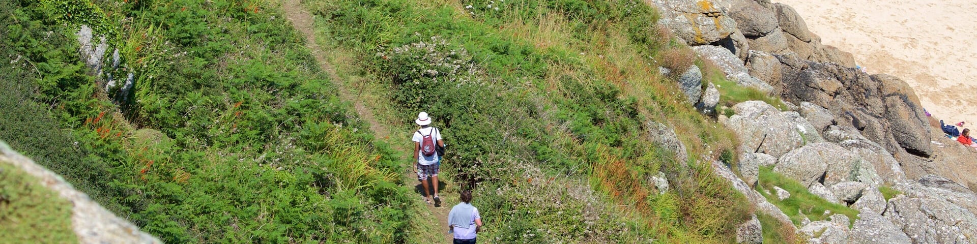 Porthcurno Beach showing a sandy beach and hiking or walking