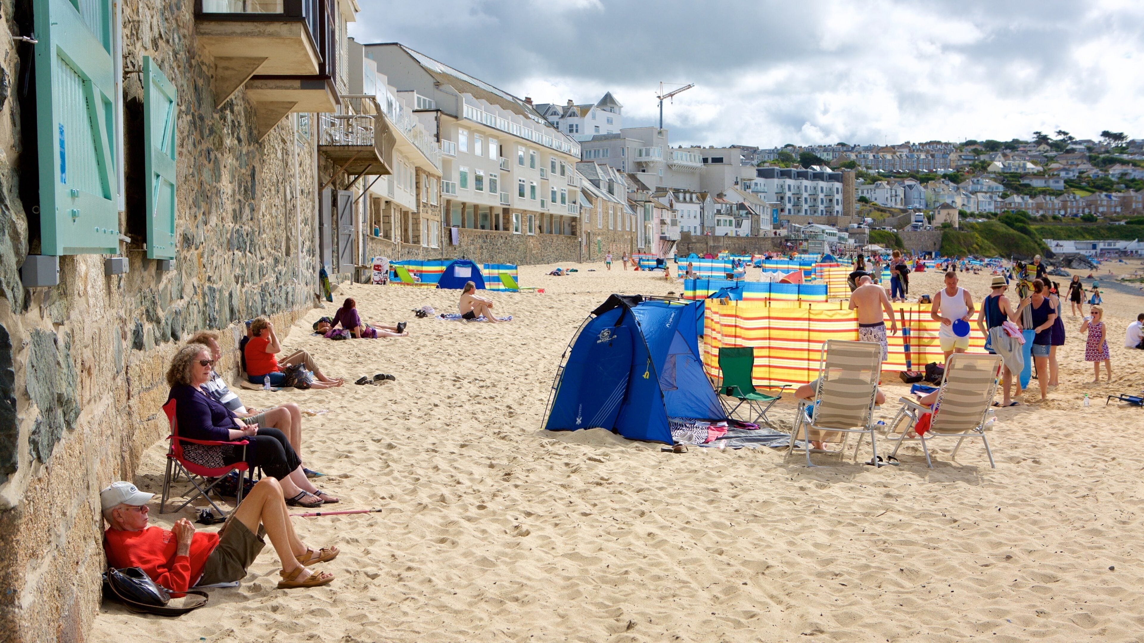 Porthmeor Beach which includes a coastal town and a beach as well as a large group of people