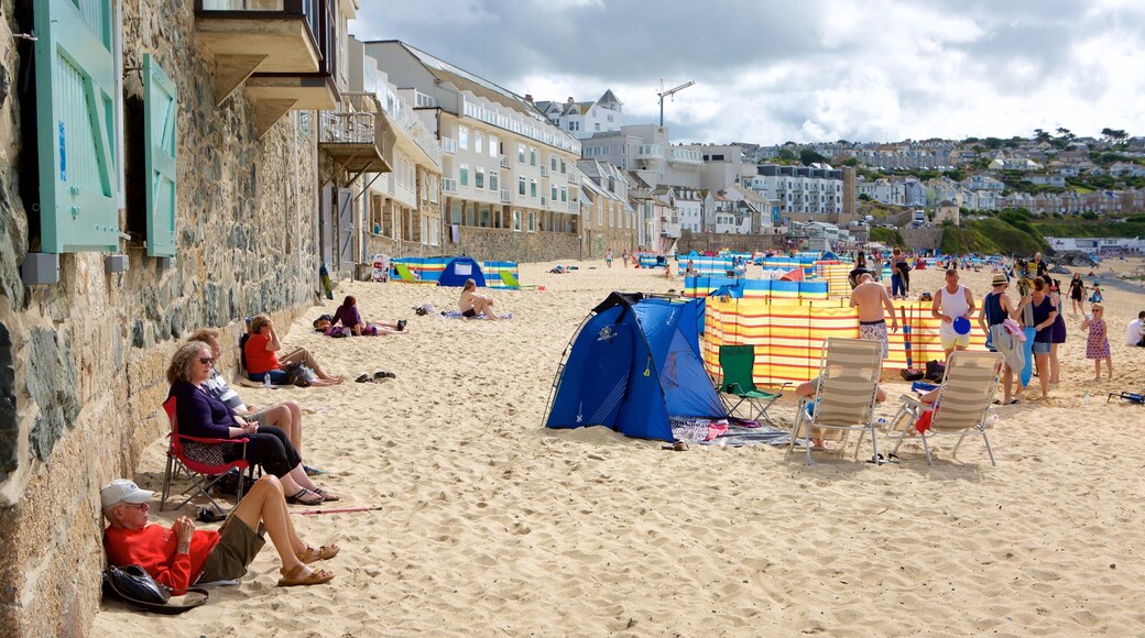 Porthmeor Beach which includes a coastal town and a beach as well as a large group of people