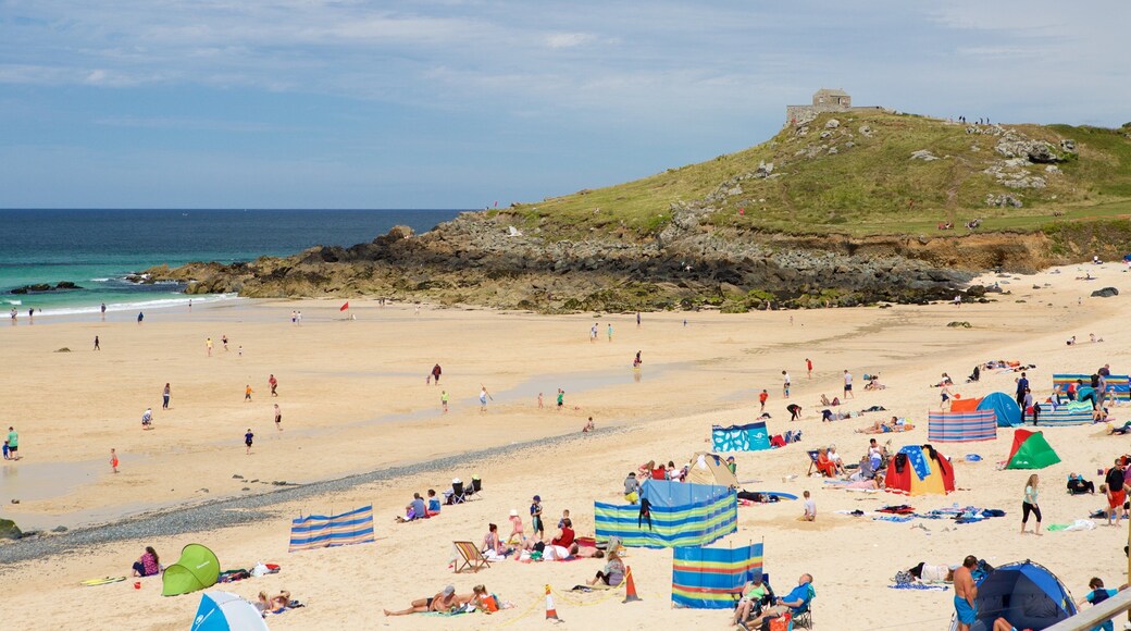 Porthmeor Beach which includes a beach and a coastal town as well as a large group of people