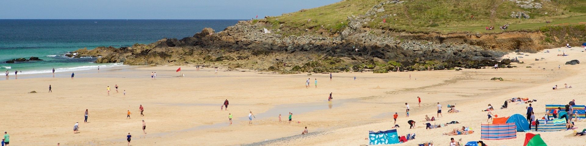 Porthmeor Beach which includes a beach and a coastal town as well as a large group of people