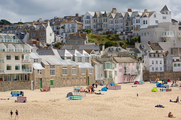 Porthmeor Beach which includes a coastal town and a sandy beach as well as a large group of people