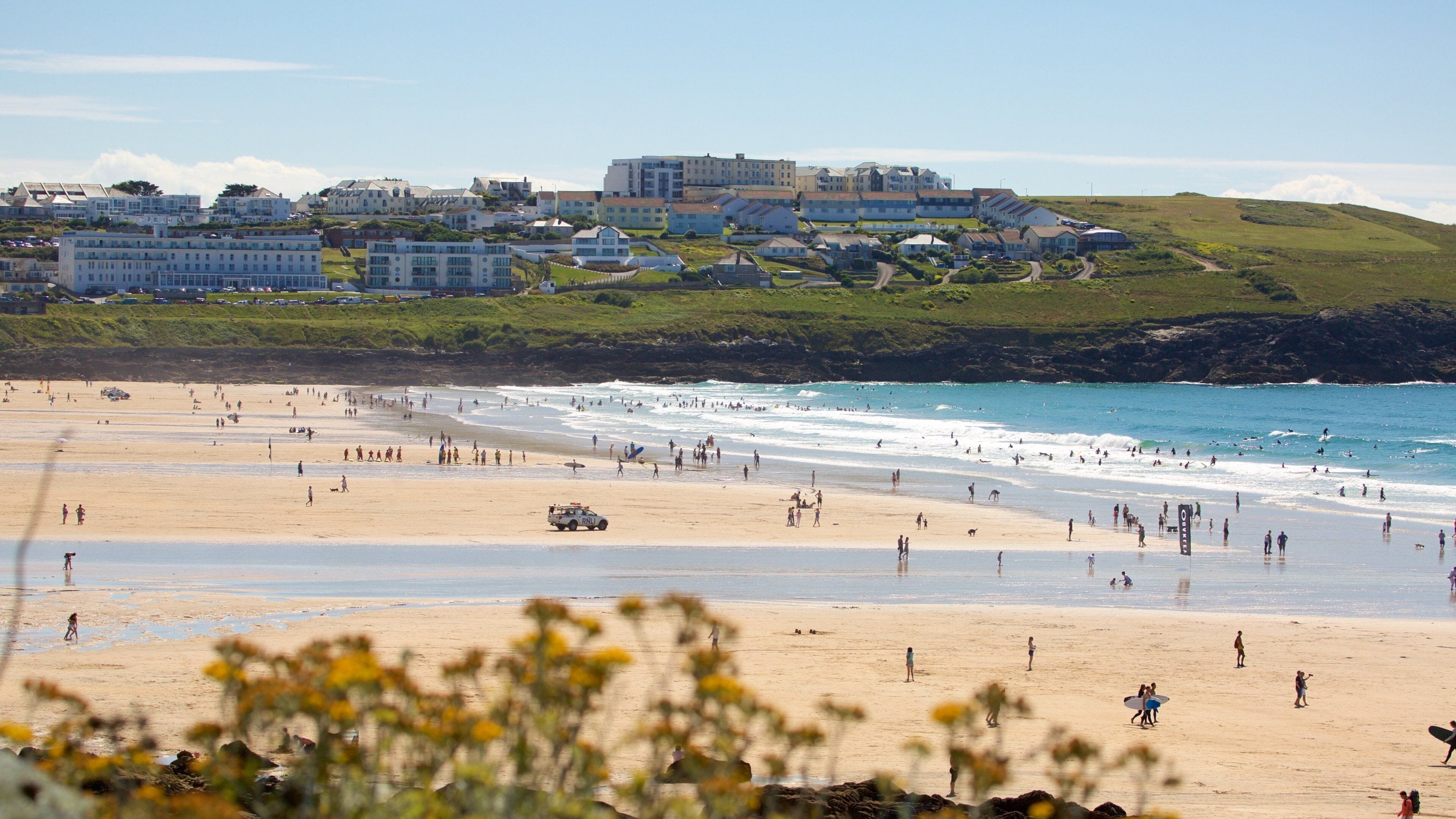 Fistral Beach showing rocky coastline, a beach and a coastal town