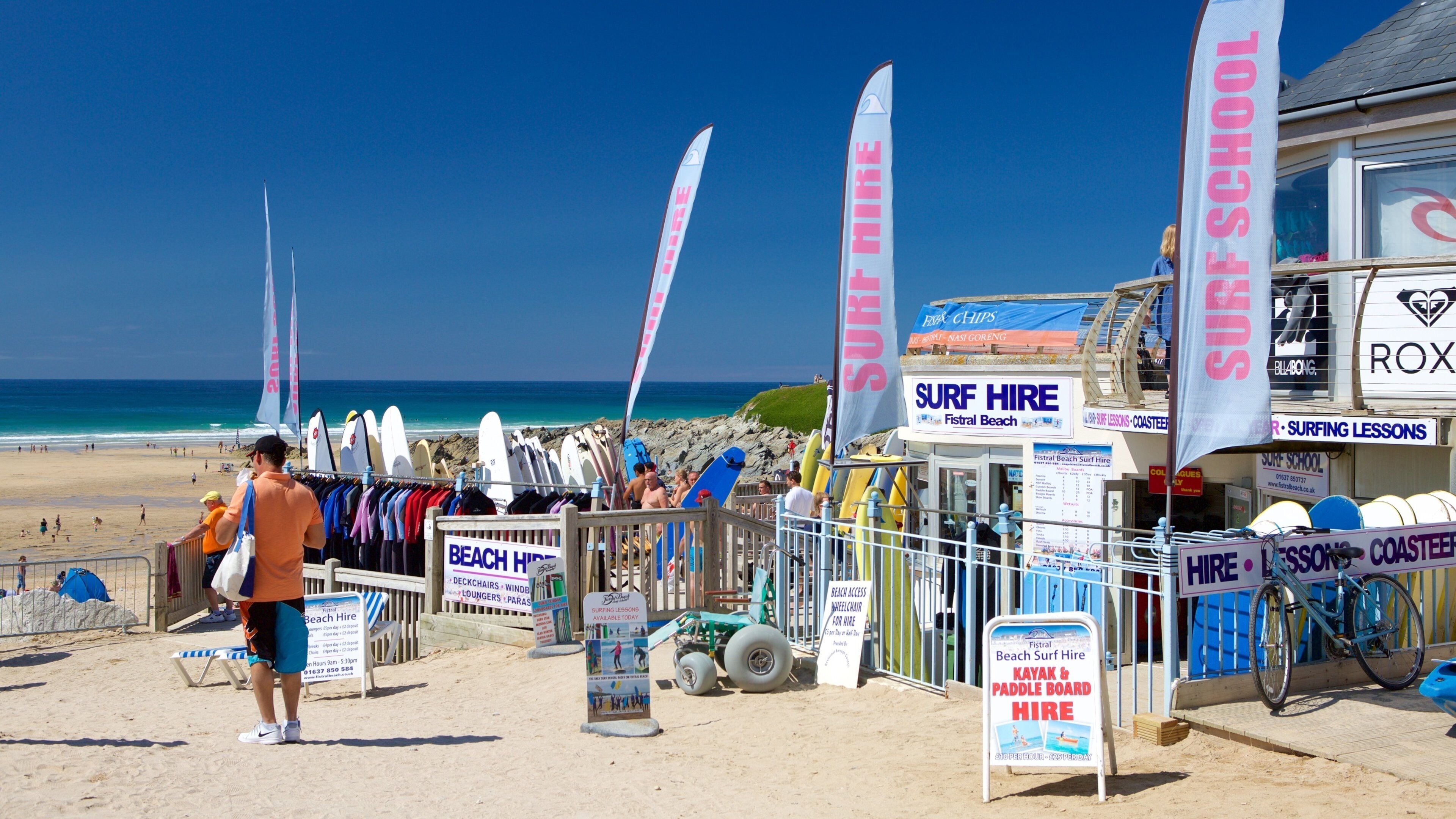 Fistral Beach featuring a beach and signage as well as an individual male