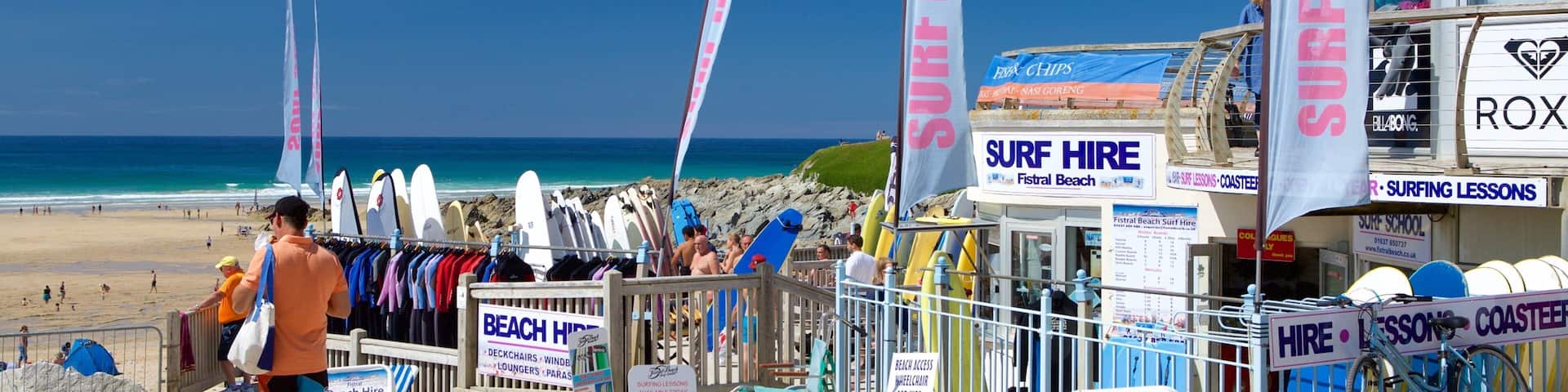 Fistral Beach welches beinhaltet Beschilderung und Strand sowie einzelner Mann
