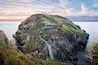 Tintagel, United Kingdom - August 12, 2016: View of Tintagel Island and legendary Tintagel castle ruins at sunset