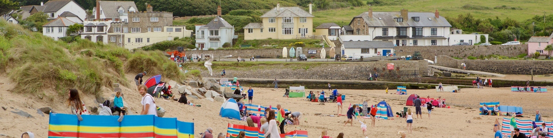 Bude Beach caracterizando uma praia de areia e uma cidade litorânea assim como um grande grupo de pessoas