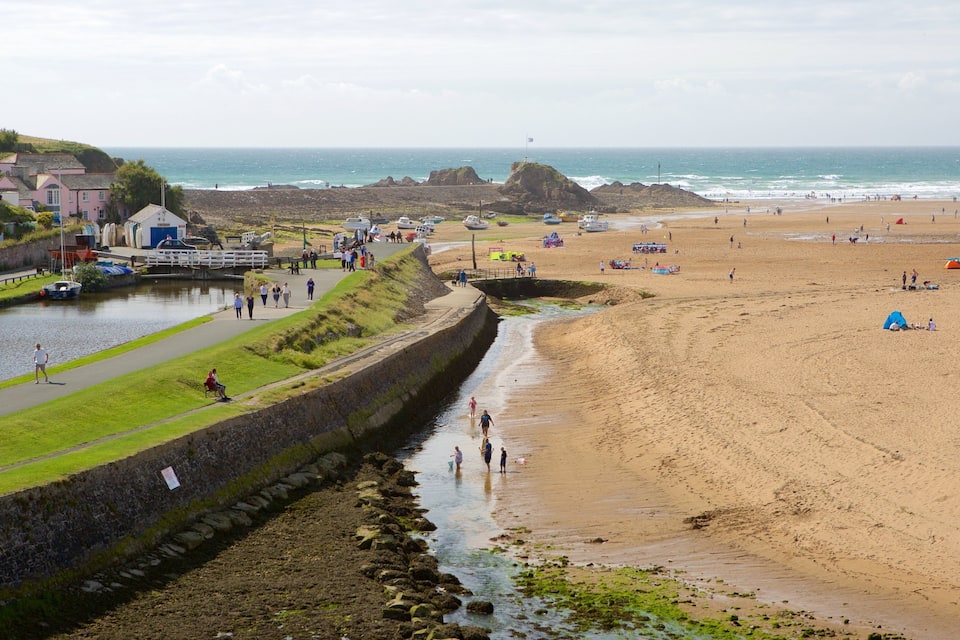 A coastal town with a sandy beach, a canal, and houses along the water's edge.