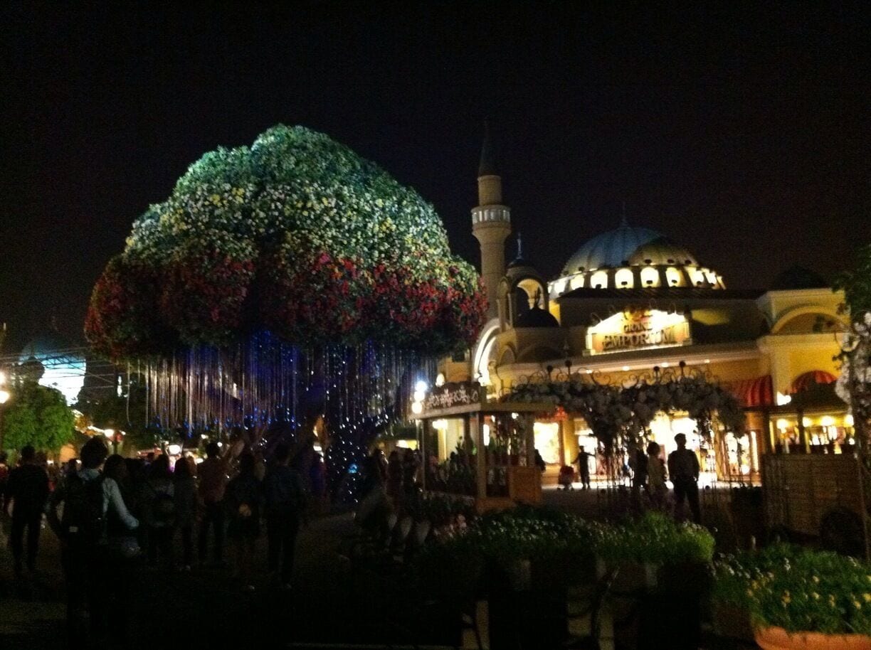A mosque with a large dome and minaret, surrounded by a crowd of people.