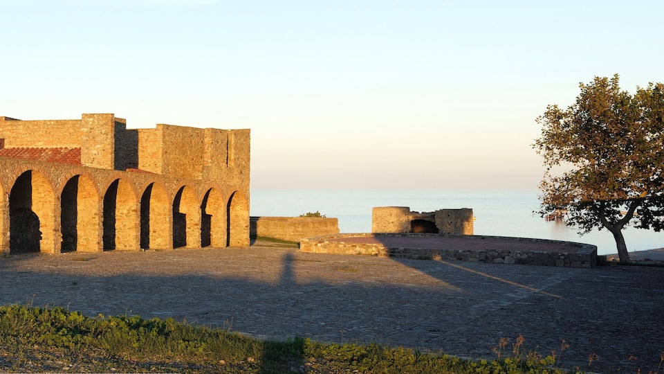 A historic stone building with multiple arches and a tower.