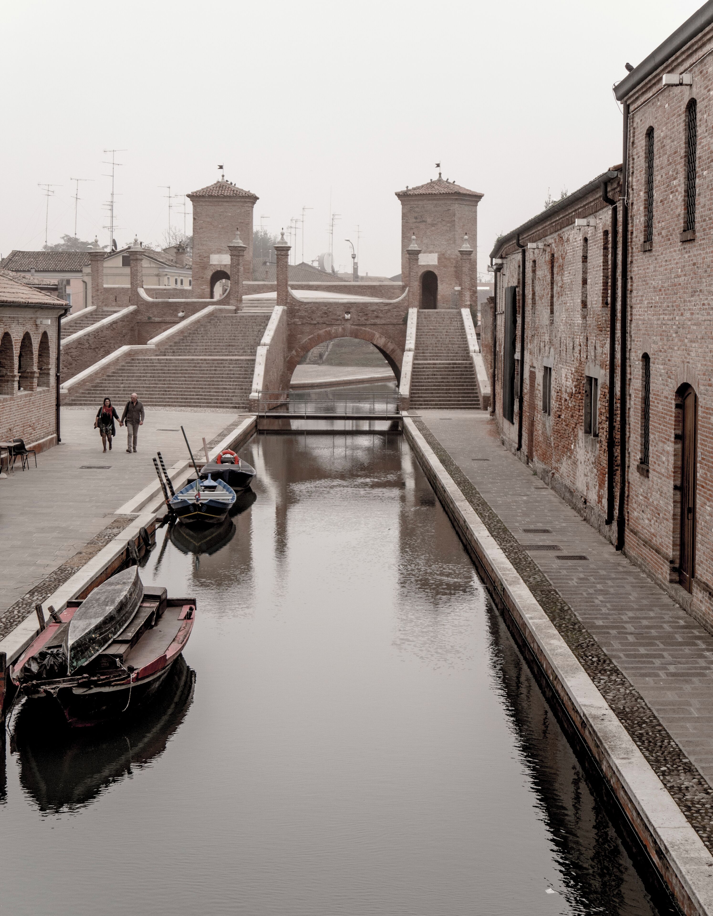 Un canal con barcos, un puente y edificios.