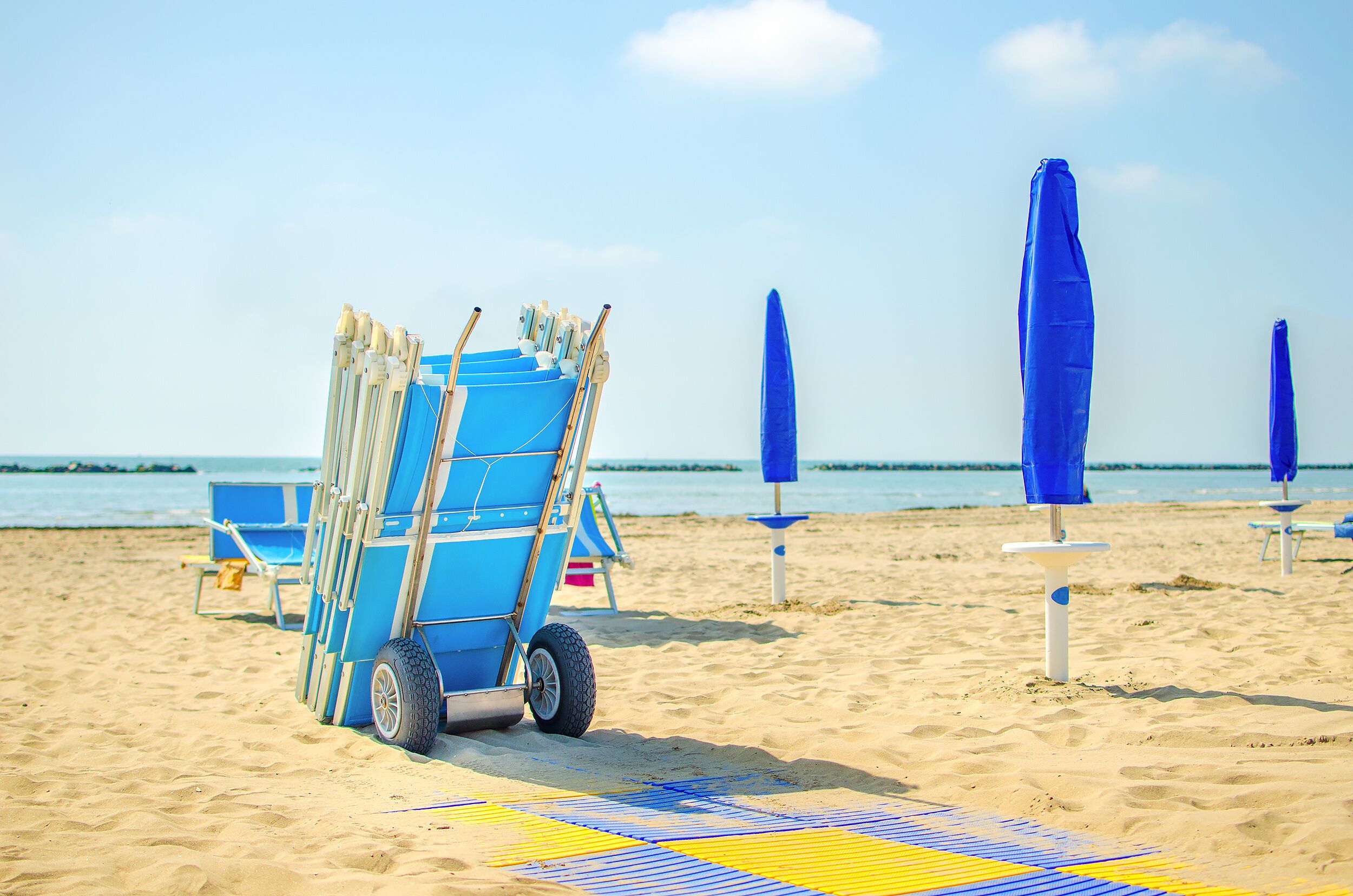 end of summer beach deckchair closed umbrella