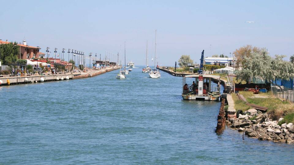 A canal with boats, a pier, and buildings along the water.