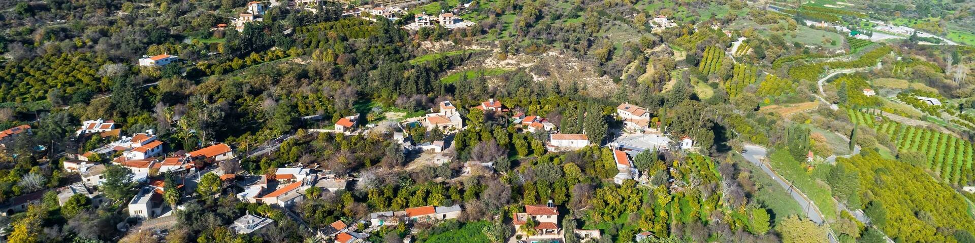 Aerial bird eye view of Miliou village hills and Akamas sea at Latchi, Paphos Cyprus. View of traditional ceramic tile roof houses near Ayii Anargyri monastery nature hotel spa from above.