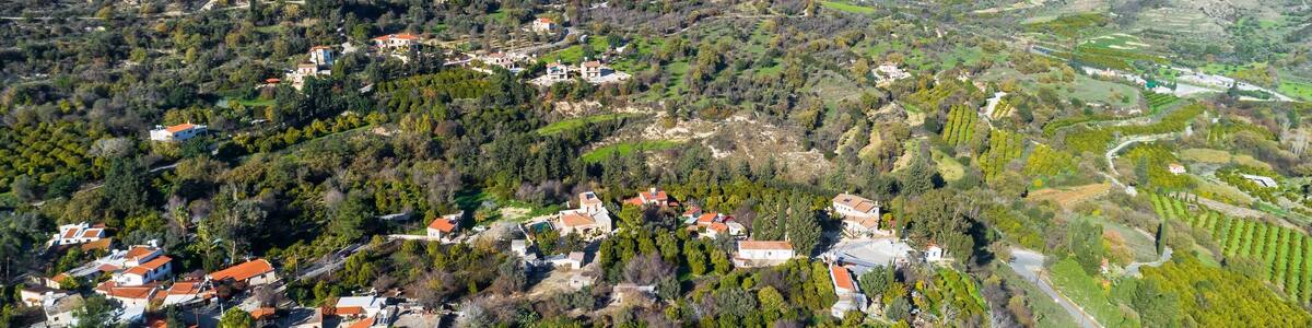 Aerial bird eye view of Miliou village hills and Akamas sea at Latchi, Paphos Cyprus. View of traditional ceramic tile roof houses near Ayii Anargyri monastery nature hotel spa from above.
