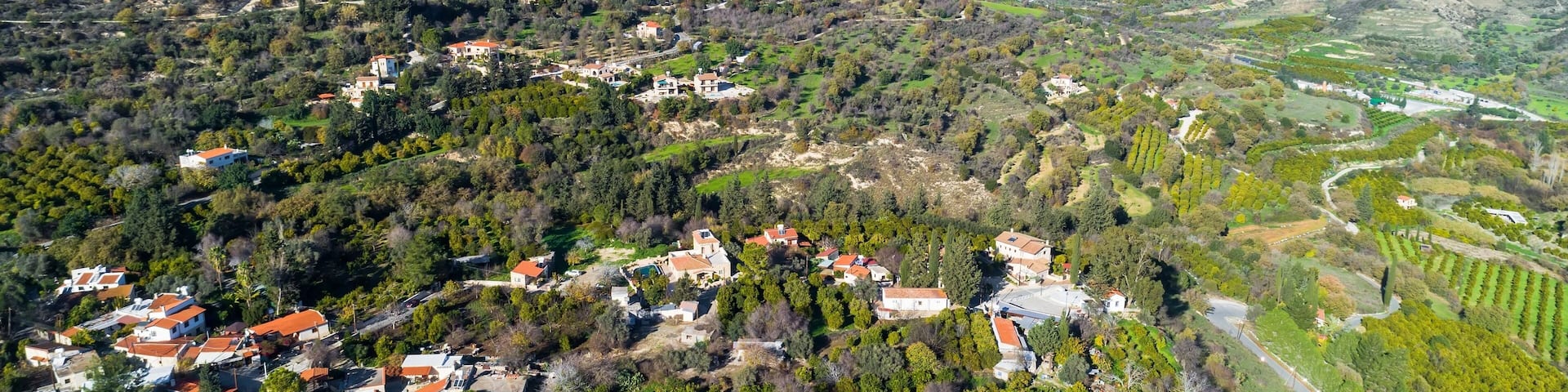 Aerial bird eye view of Miliou village hills and Akamas sea at Latchi, Paphos Cyprus. View of traditional ceramic tile roof houses near Ayii Anargyri monastery nature hotel spa from above.