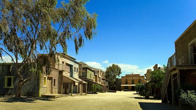 A historic town square with wooden buildings, a hotel, and a saloon.
