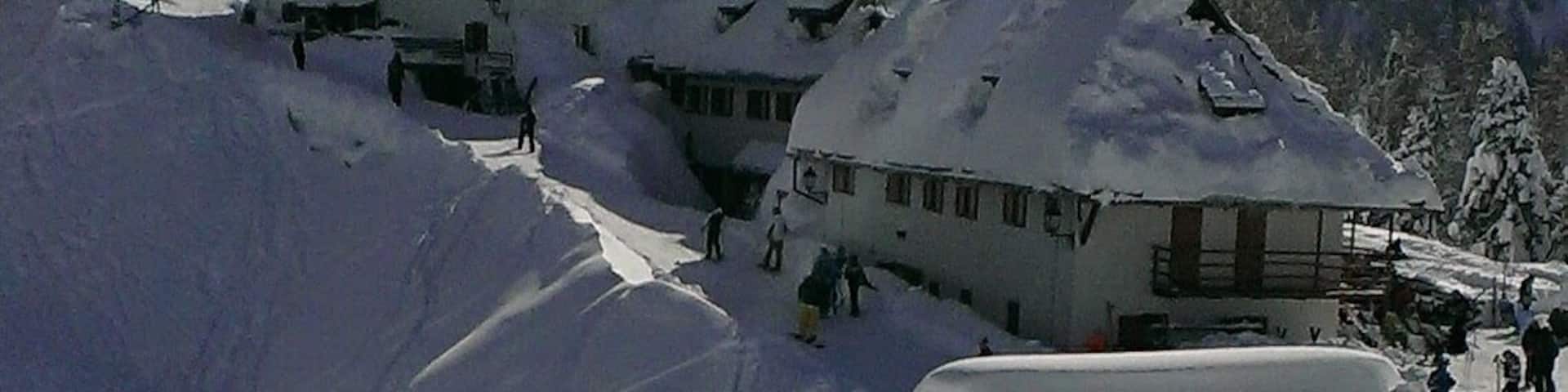 A snow-covered mountain village with traditional buildings and a church.