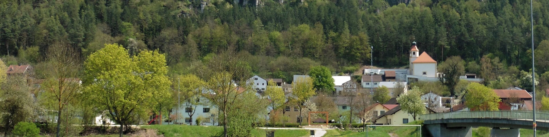 A town with buildings in the foreground and a castle on a cliff in the background.