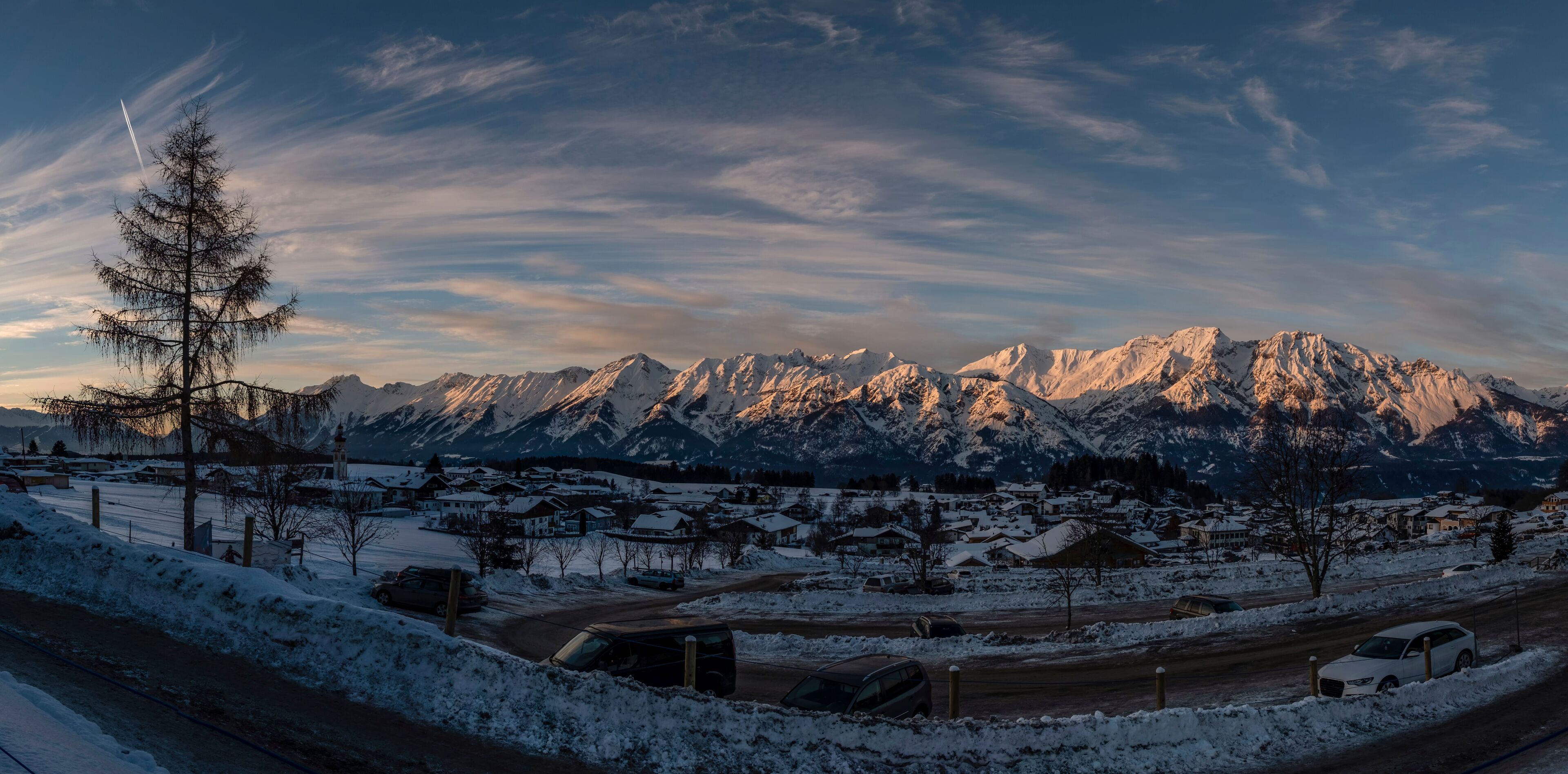 A snow-covered mountain range with a town in the foreground.
