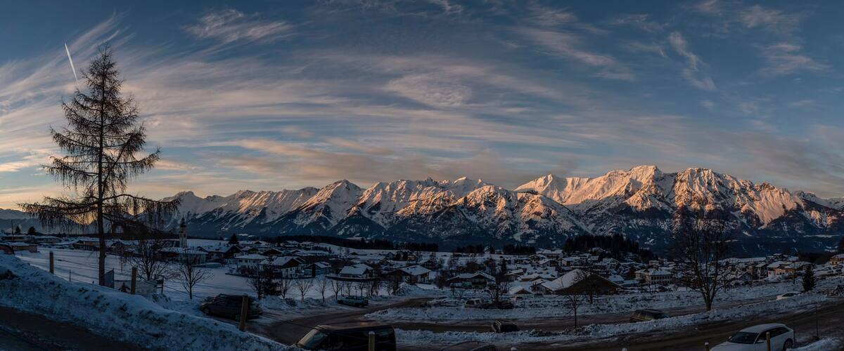 A snow-covered mountain range with a town in the foreground.