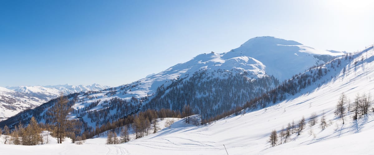 A snow-covered mountain range with clear skies.