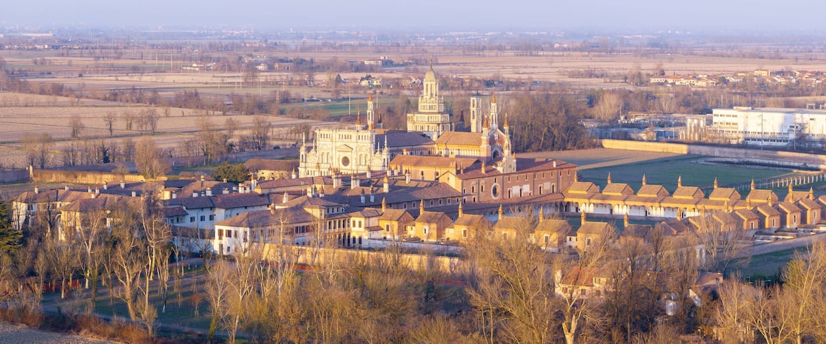 A historic town with a prominent church, a large square, and surrounding fields.