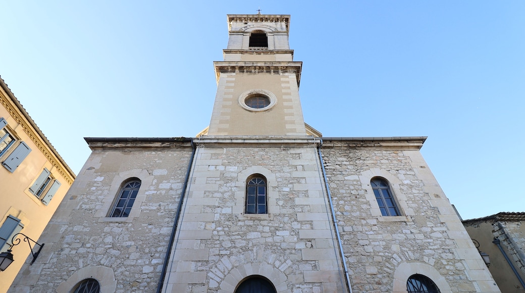 Une église historique dotée d’un clocher, de fenêtres en arc et d’une façade en pierre.