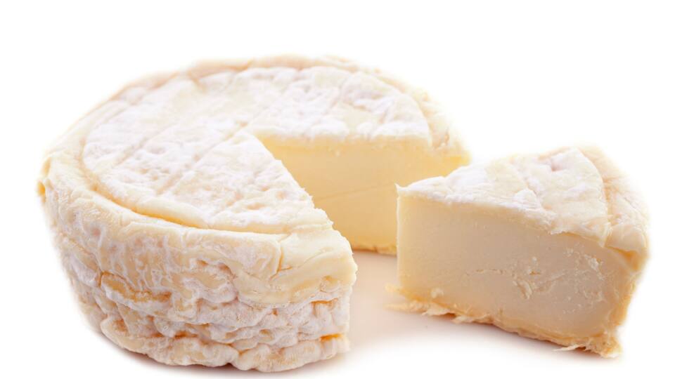 A wheel of cheese with a wedge cut out.