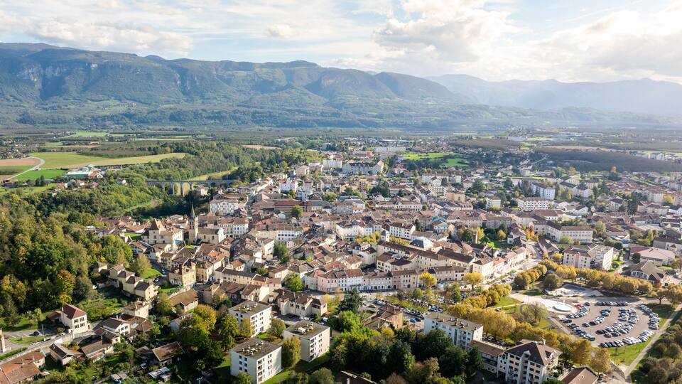 A town with a river, mountains, and a bridge.