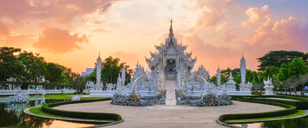 A temple complex with intricate architecture and a reflective pond.