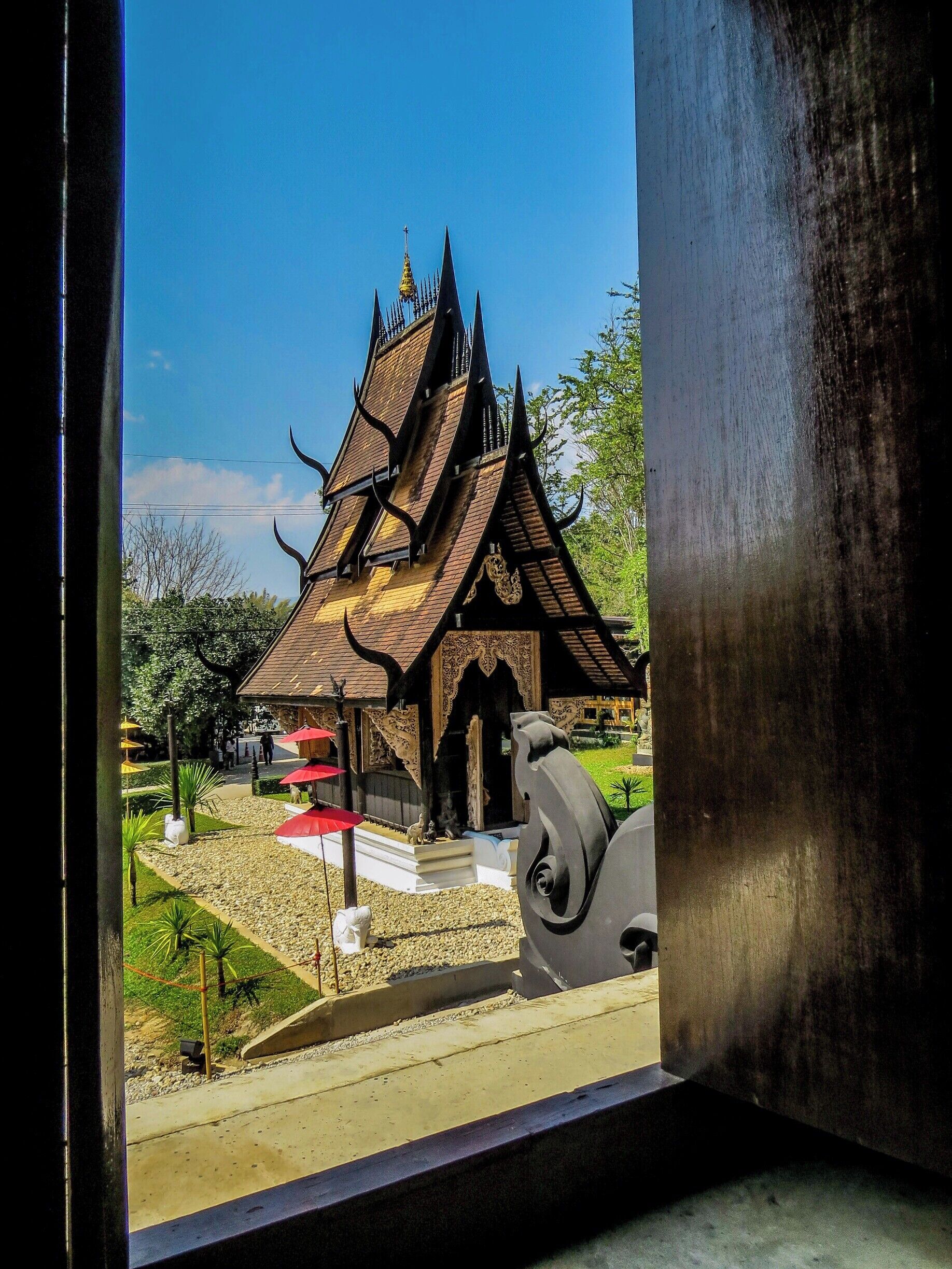 A traditional Thai temple with a multi-tiered roof and ornate decorations.