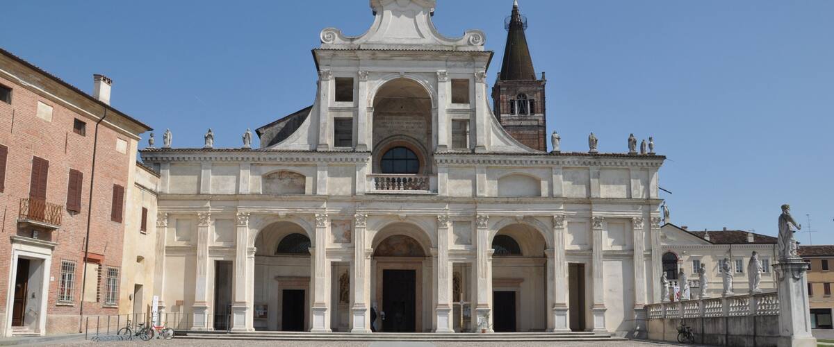 A historic church with a prominent bell tower and arched entrances.