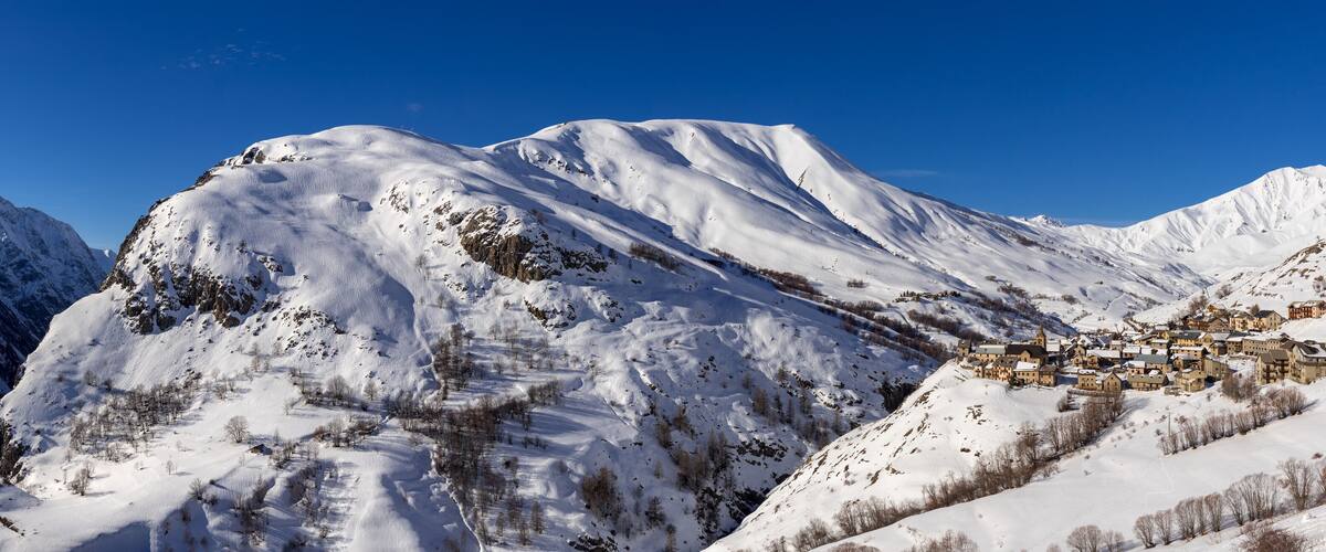 A snow-covered mountain with a village nestled at its base.