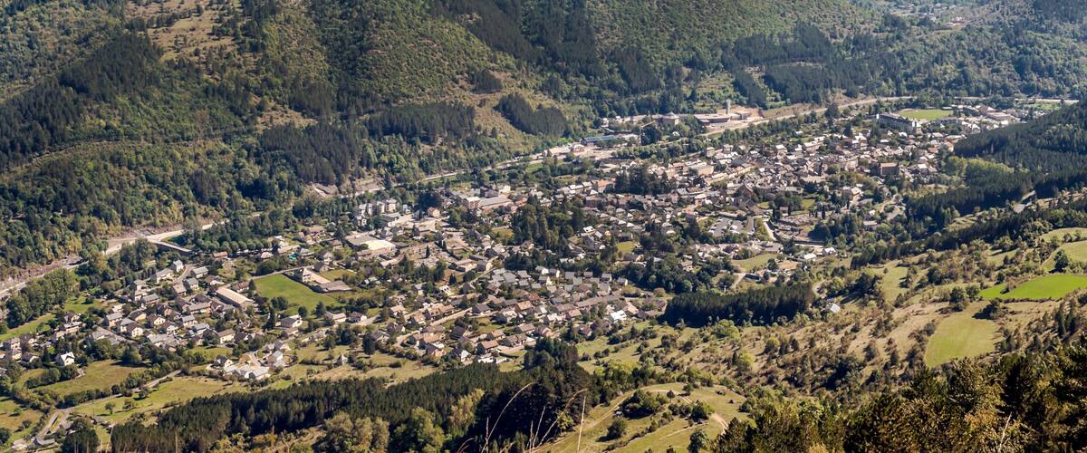 A town nestled in a valley surrounded by forested hills.