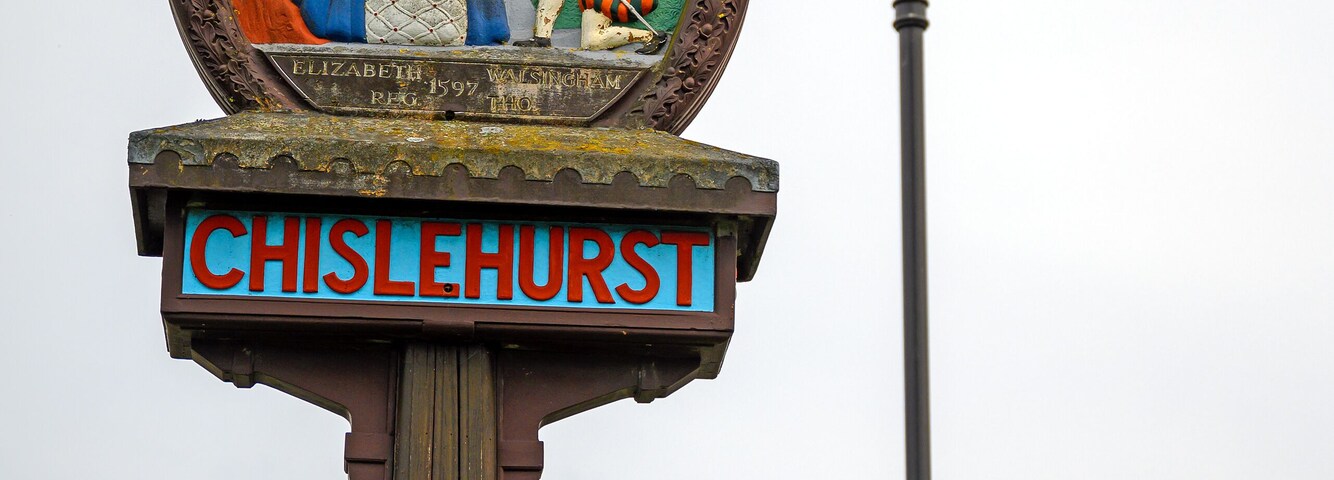 Un cartel histórico con un escudo y el nombre 'CHISLEHURST'.
