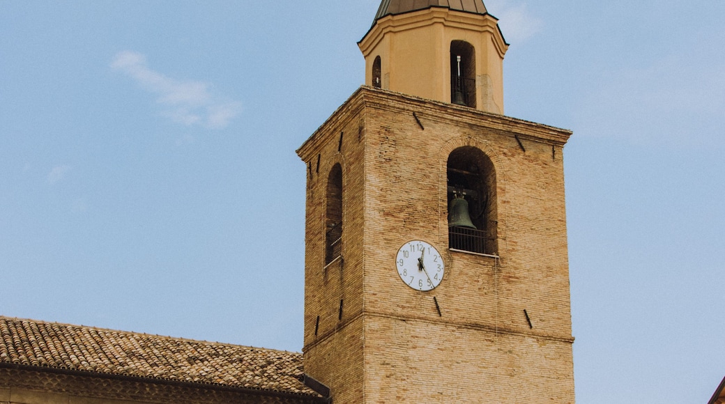 Una iglesia histórica con un campanario, un reloj y un tejado de baldosas.