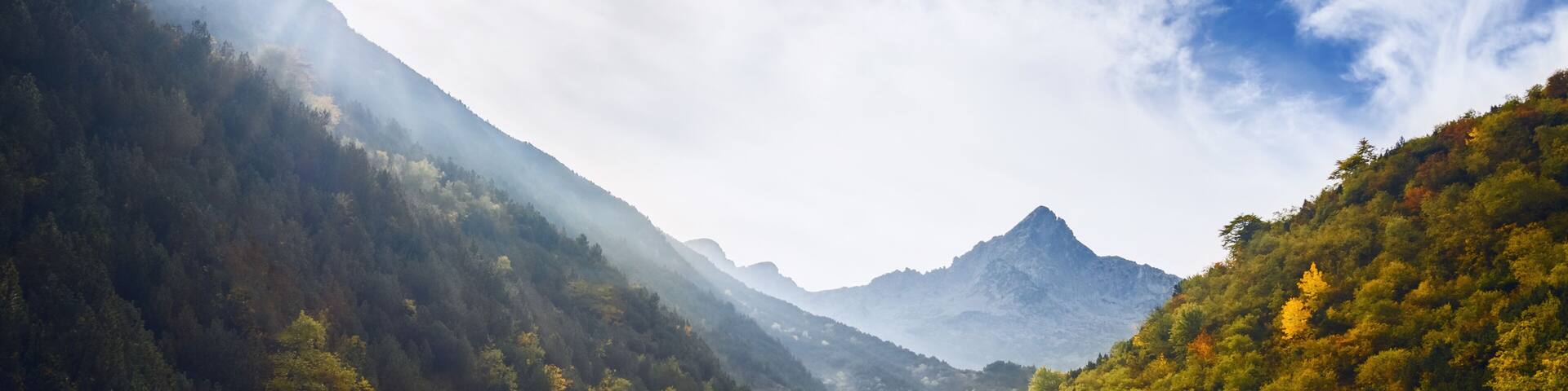 Morning light between trees and mountains, on the path to the lake of Frisson, in Maritime Alps Park, Piedmont Italy